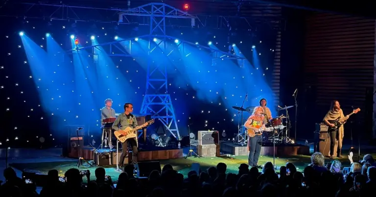 Jesse Welles (third from left) with his band at Dillon Amphitheater Saturday night. The backdrop alludes to his 'Under the Powerlines' album released this year. | Photo: Alex Miller